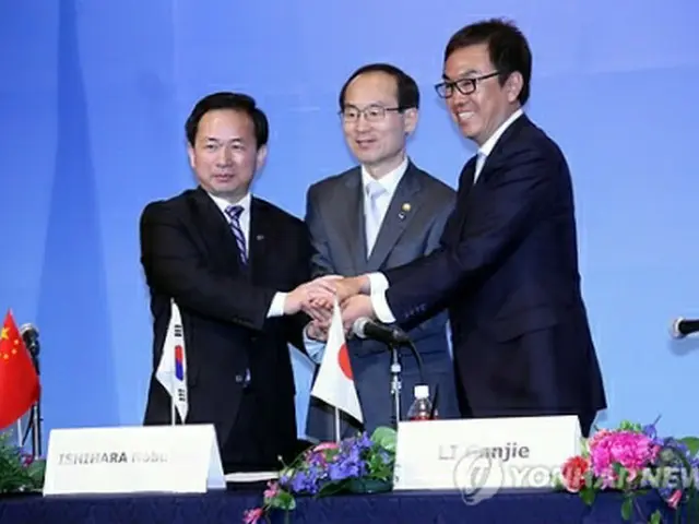 共同声明に署名した後に握手する尹成奎環境部長官（中央）ら＝６日、北九州（聯合ニュース）