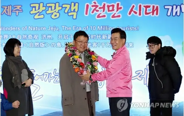 キム・ドゥイルさん（左から2人目）に祝福の花の首輪をかける禹知事＝28日、済州（聯合ニュース）