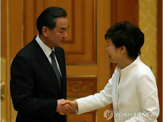 青瓦台で王毅外相と握手する朴槿恵大統領＝26日、ソウル（聯合ニュース）