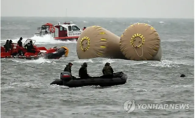 捜索活動を行う救助チーム＝（聯合ニュース）