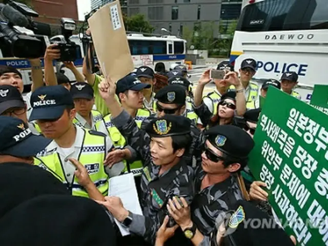 日本大使館に抗議書簡を伝達しようとして警察に制止される団体会員ら＝２２日、ソウル（聯合ニュース）