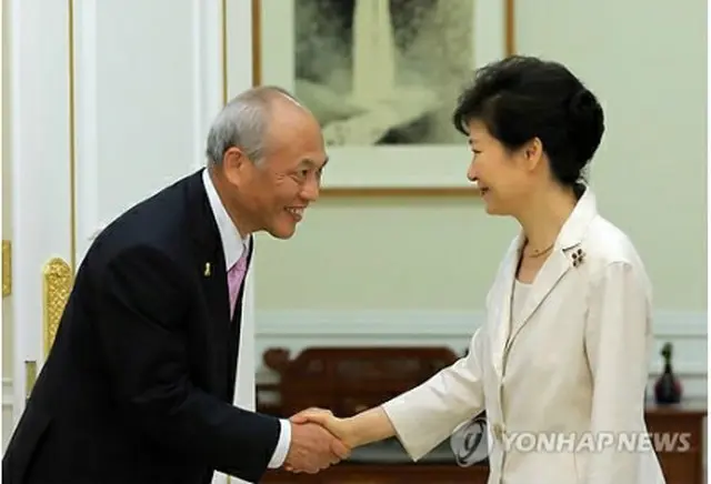 舛添知事と握手する朴大統領（右）＝25日、ソウル（聯合ニュース）