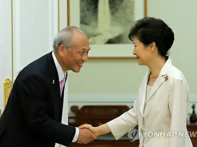 舛添知事と握手する朴大統領（右）＝25日、ソウル（聯合ニュース）