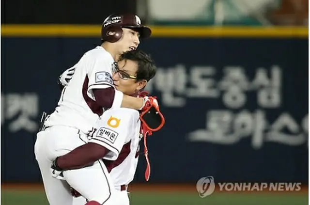 韓国プロ野球初の２００本安打を達成し、コーチと抱き合う徐建昌＝１７日、ソウル（聯合ニュース）