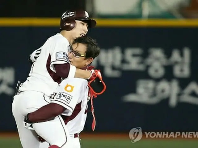 韓国プロ野球初の２００本安打を達成し、コーチと抱き合う徐建昌＝１７日、ソウル（聯合ニュース）