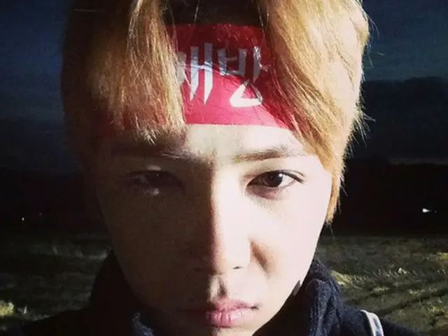 韓国男性バンド「FTISLAND」イ・ホンギが赤いはちまきを巻いてデモ中の姿を公開した。（提供:OSEN)