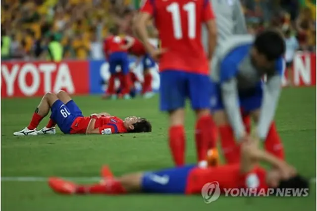 試合後、グラウンドに倒れ込む赤いユニホームの韓国イレブン＝３１日、シドニー（聯合ニュース）