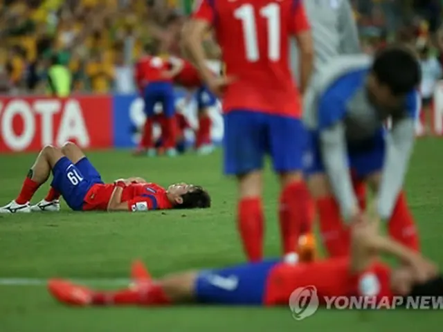 試合後、グラウンドに倒れ込む赤いユニホームの韓国イレブン＝３１日、シドニー（聯合ニュース）