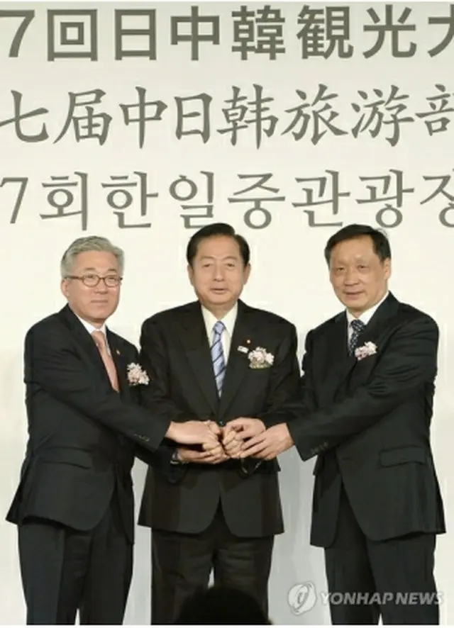 握手する（左から）金長官、太田氏、李氏＝１２日、東京（共同＝聯合ニュース）