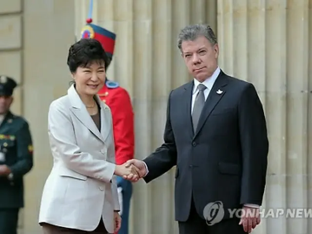 サントス大統領（右）と握手を交わす朴大統領＝１７日、ボゴタ（聯合ニュース）