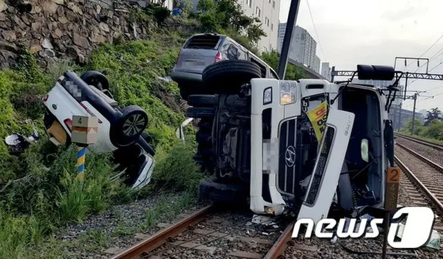 韓国・釜山市内で下水処理作業をしていた浄化槽タンクローリーの車両が、ブレーキの破裂によって下り坂を下っていき、周辺に駐車されていた車と共に線路上に転落する事故が発生した。（提供:news1）