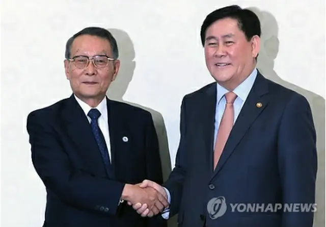 握手を交わす崔副首相（右）と佐々木会長＝１２日、ソウル（聯合ニュース）