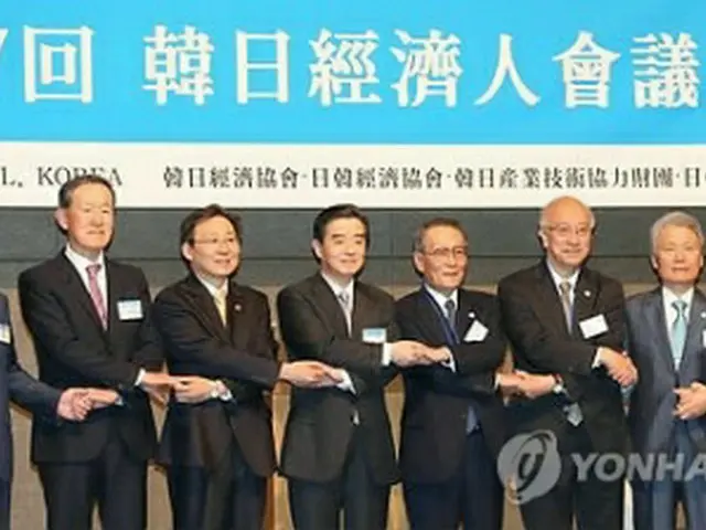手を取り合って記念撮影する会議の出席者＝１３日、ソウル（聯合ニュース）