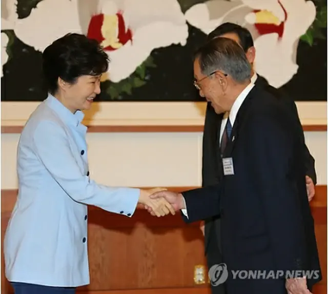 佐々木会長（右）と握手する朴大統領＝１３日、ソウル（聯合ニュース）