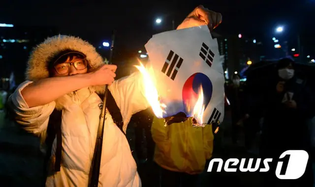 先月、セウォル号追悼集会の現場で、太極旗（韓国の国旗）を燃やして騒動を起こした20代男性が警察に逮捕された。（提供:news1）