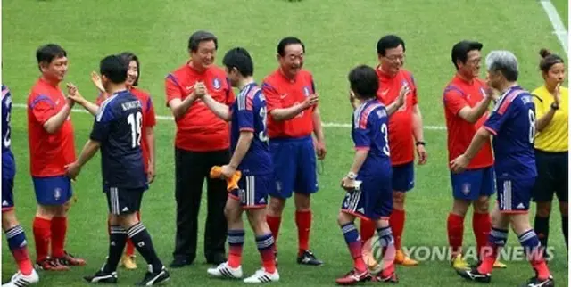 試合開始前にあいさつを交わす両国議員＝１３日、ソウル（聯合ニュース）