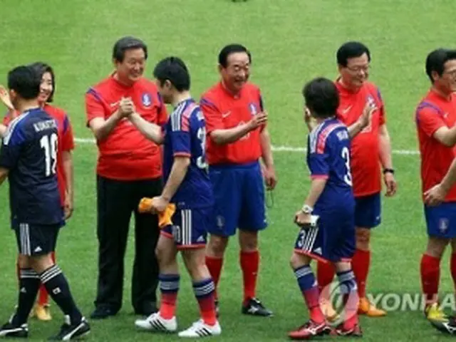 試合開始前にあいさつを交わす両国議員＝１３日、ソウル（聯合ニュース）