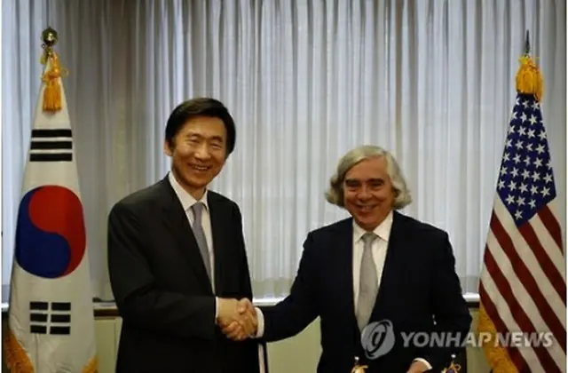 原子力協定に正式署名してから握手を交わす尹長官（左）とモニズ長官＝（聯合ニュース）