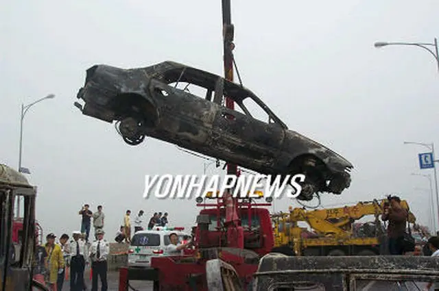 事故現場から搬出される焼け焦げた乗用車＝3日、唐津（聯合）