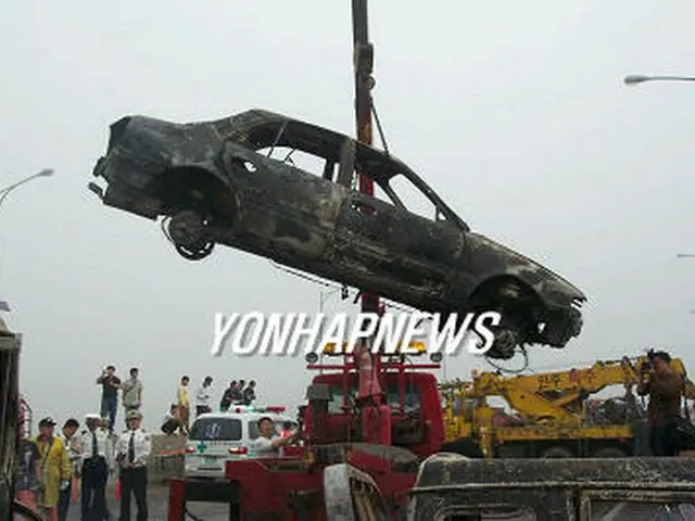 事故現場から搬出される焼け焦げた乗用車＝3日、唐津（聯合）