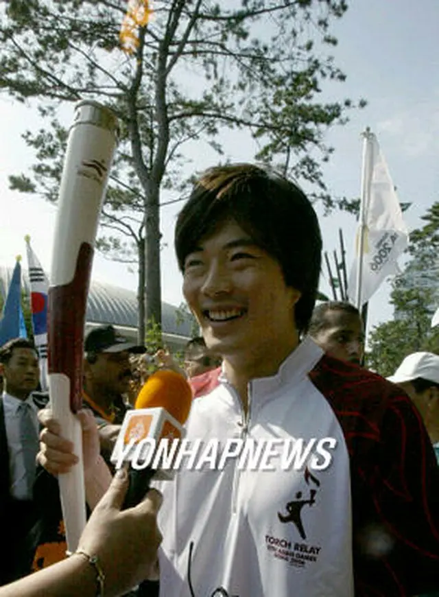 聖火ランナーとして走るクォン・サンウさん＝14日、釜山（聯合）