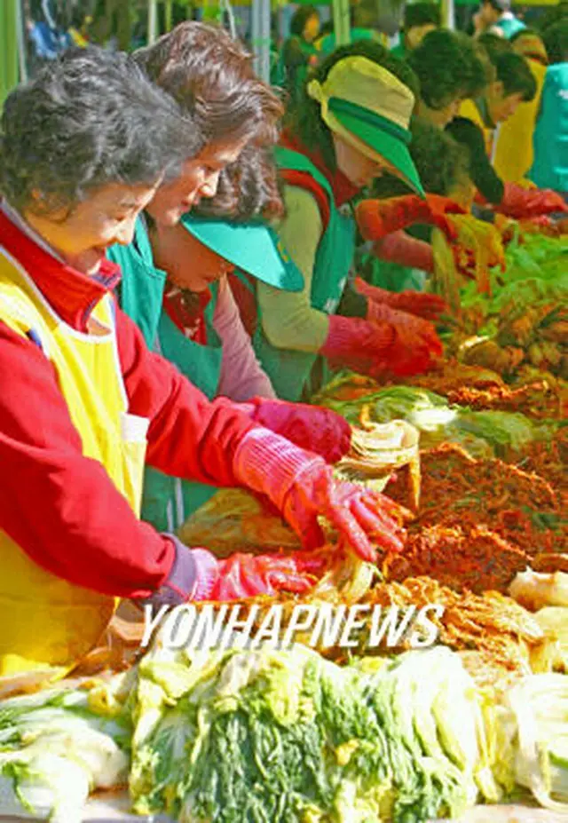 キムチ漬けの季節。ソウル市瑞草区庁で低所得世帯向けにキムチを漬けるボランティア＝7日、ソウル（聯合）