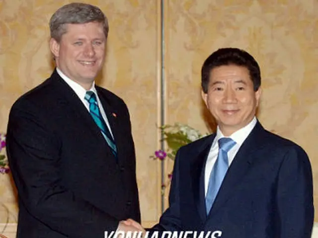 首脳会談前に握手する盧武鉉大統領（右）とカナダのハーパー首相＝18日、ハノイ（聯合）