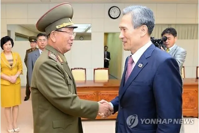 協議後、握手を交わす韓国の金寛鎮国家安保室長（右）と北朝鮮の黄炳誓朝鮮人民軍総政治局長（統一部提供）＝２５日、ソウル（聨合ニュース）