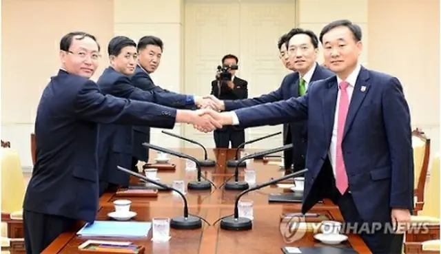 協議で握手を交わす韓国代表（右）と北朝鮮代表（統一部提供）＝７日、ソウル（聯合ニュース）
