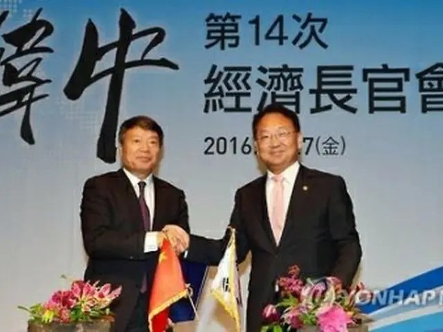 握手を交わす柳氏（右）と徐氏（企画財政部提供）＝２７日、ソウル（聯合ニュース）