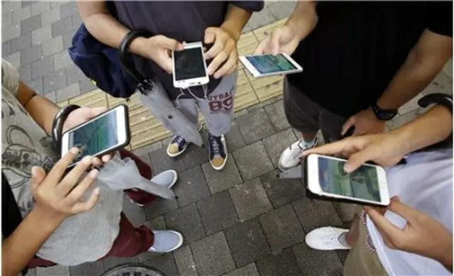 街中でモバイルゲームを楽しむ市民（資料写真）＝（聯合ニュース）