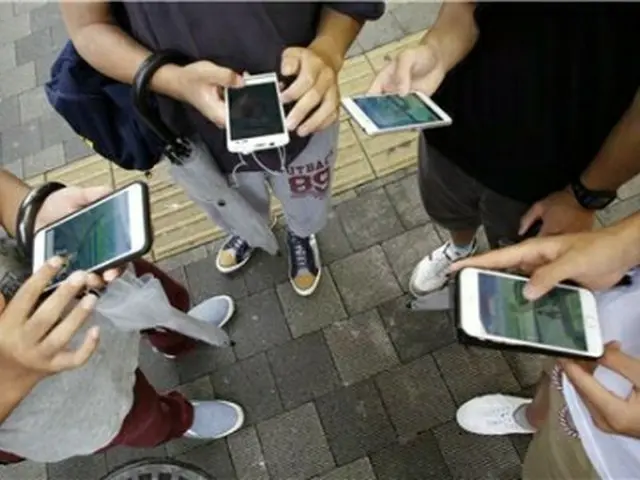 街中でモバイルゲームを楽しむ市民（資料写真）＝（聯合ニュース）