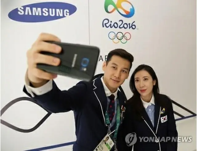 サムスン電子が提供したスマホを試す韓国代表＝（聯合ニュース）