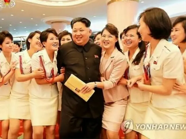 北朝鮮の女性音楽グループ、牡丹峰（モランボン）楽団の女性たちに囲まれ、笑顔を浮かべる正恩氏（中央）＝（聯合ニュース）