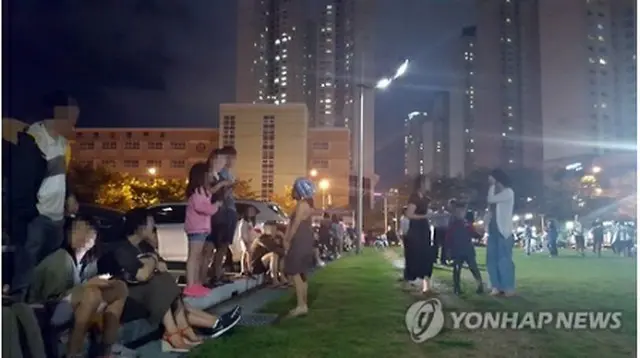 揺れを感じて外に避難した釜山市民たち＝１２日、釜山（聯合ニュース）