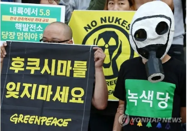 「福島を忘れないで」と書かれたプラカード(左）を手にした出席者＝１３日、ソウル（聯合ニュース）