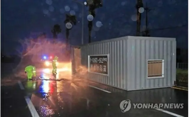 風に吹き飛ばされたコンテナが道路をふさいでいる＝５日、西帰浦（聯合ニュース）