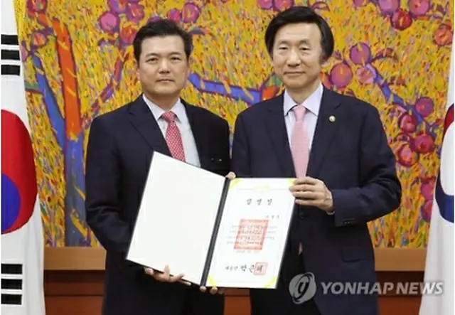 １２日に尹炳世（ユン・ビョンセ）外交部長官から任命状を受け取った李大使（左）＝（聯合ニュース）