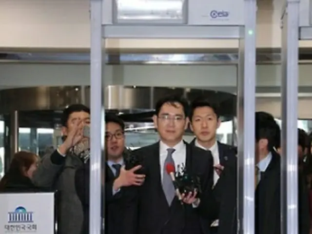 聴聞会に出席するため、国会に入るサムスン電子の李副会長＝６日、ソウル（聯合ニュース）