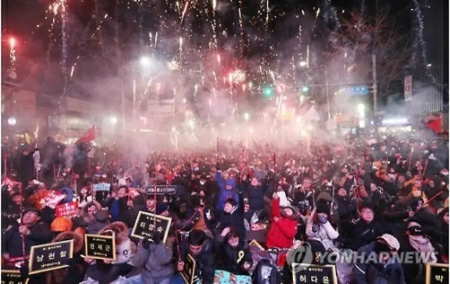 １０日に開催された集会で花火を打ち上げ、朴大統領の弾劾案可決を喜ぶ市民ら＝（聯合ニュース）