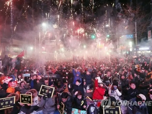 １０日に開催された集会で花火を打ち上げ、朴大統領の弾劾案可決を喜ぶ市民ら＝（聯合ニュース）