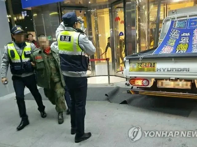 逮捕された男とトラック＝１９日、ソウル（聯合ニュース）