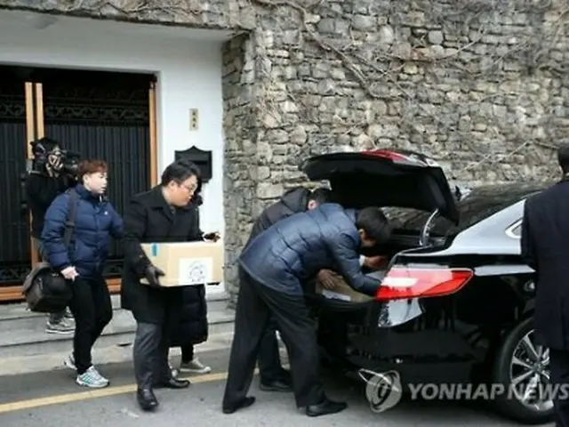 押収物を車両に運ぶ捜査官＝（聯合ニュース）