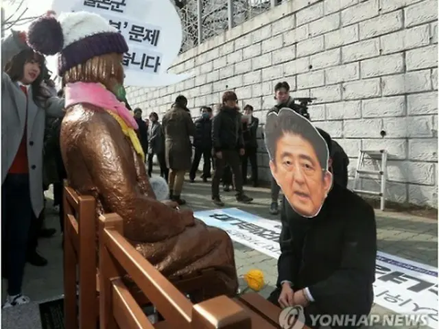 今月２日、釜山の日本総領事館前に設置されている少女像に安倍晋三首相が謝罪するパフォーマンスを行う市民団体のメンバー＝釜山（聯合ニュース）
