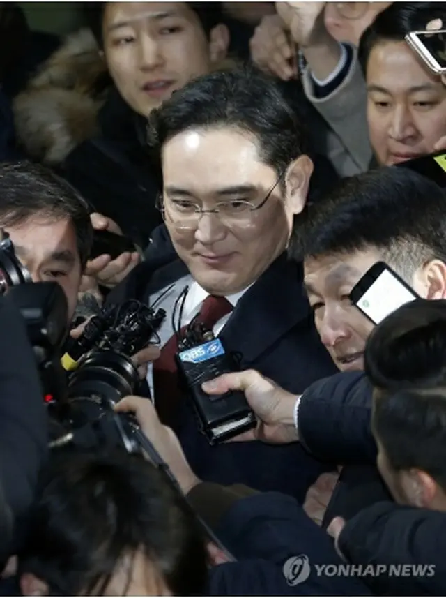 取り調べを終え、捜査チームの事務所を出る李副会長＝１３日、ソウル（聯合ニュース）