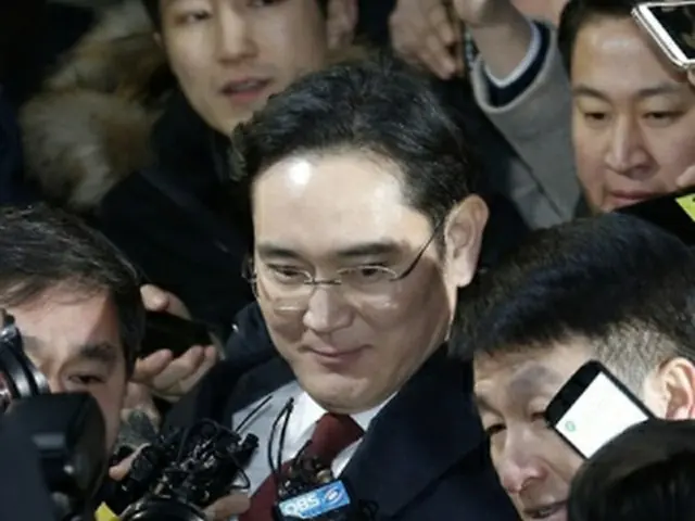 取り調べを終え、捜査チームの事務所を出る李副会長＝１３日、ソウル（聯合ニュース）