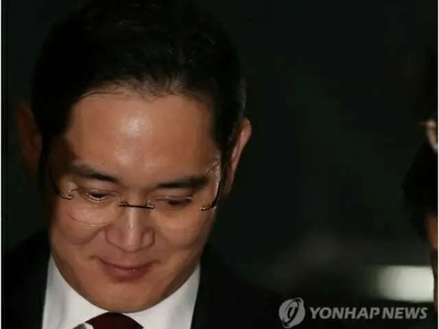取り調べを終え、捜査チームの事務所を出る李副会長＝１３日、ソウル（聯合ニュース）