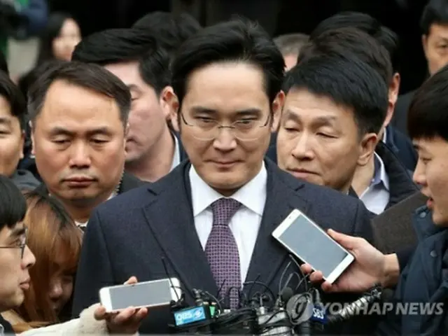 硬い表情で地裁を出る李在鎔氏＝１８日、ソウル（聯合ニュース）
