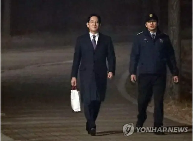 疲れた表情で拘置所から出てくる李副会長＝１９日、ソウル（聯合ニュース）