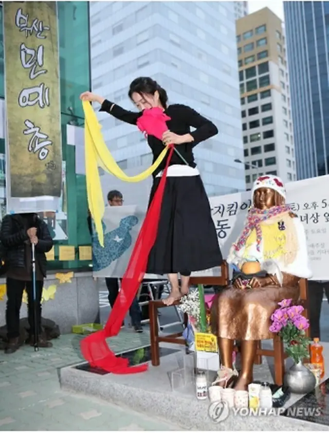 少女像のそばでパフォーマンスを行う舞踊家＝４日、釜山（聯合ニュース）